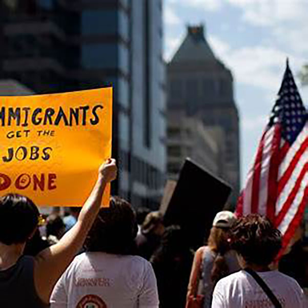 Group of people holding signs at an immigration protest.